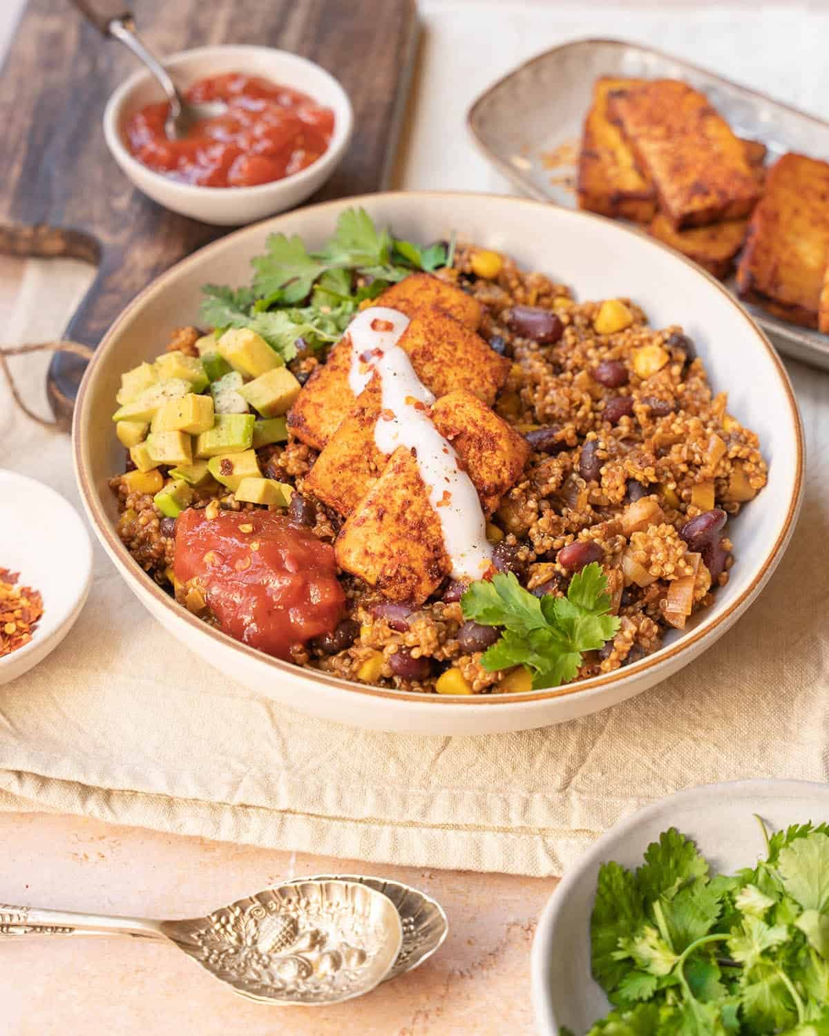 A bowl of quinoa, baked tofu, fresh coriander and salsa.