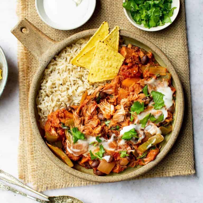 Jackfruit chilli in a bowl topped with coriander and vegan sour cream