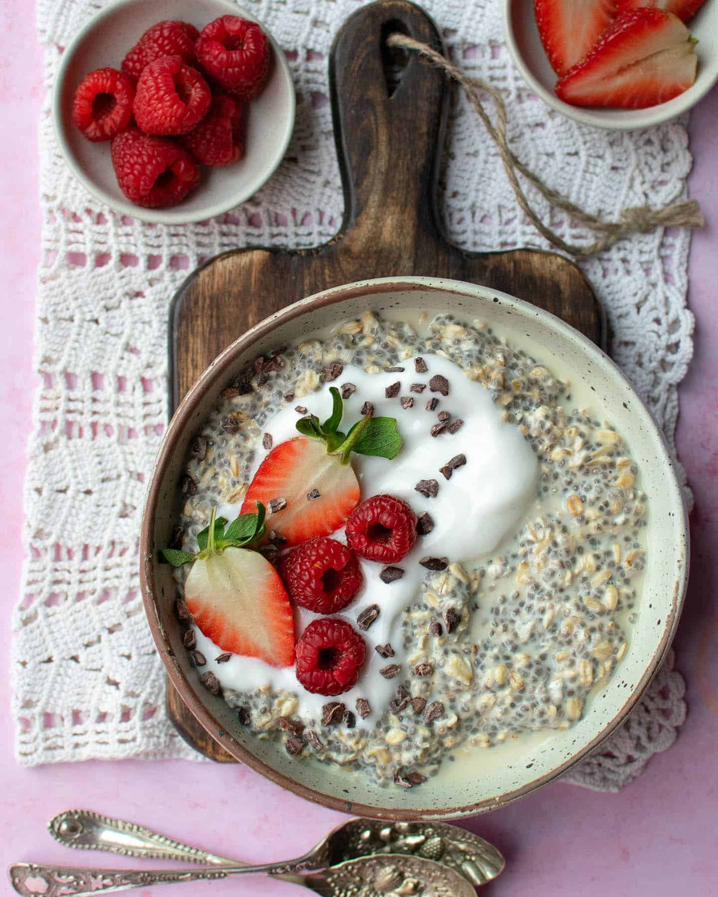 Overnight oats topped with raspberries, strawberries and cacao nibs