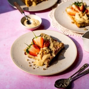 Vegan baked oats with strawberries topped with yoghurt and walnuts.