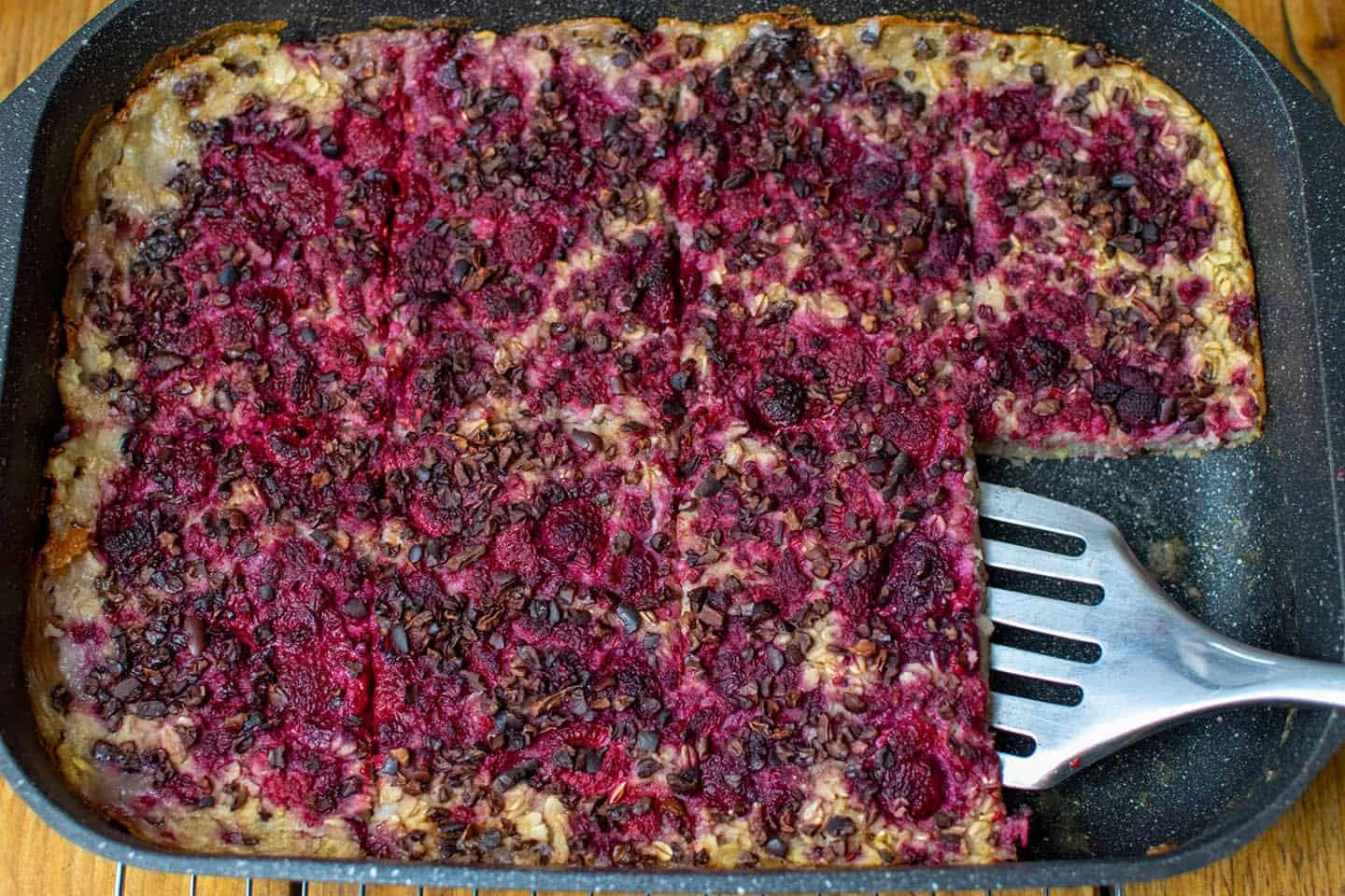 Vegan baked oatmeal with raspberry and chocolate nibs in a tray