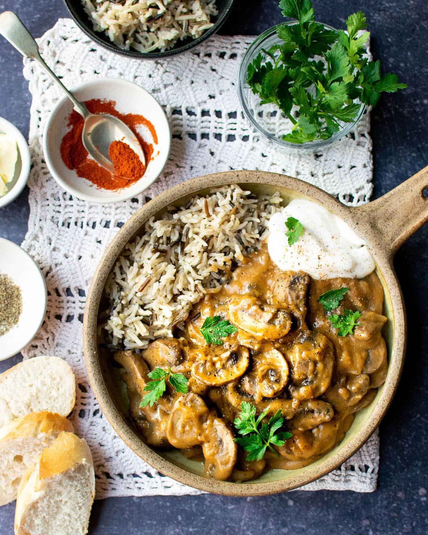 An earthenware bowl of mushroom stroganoff, served with wild rice and a dollop of vegan creme fraiche