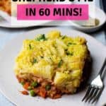 A pinterest image that shows two plates of vegan shepherd's pie with a fork on the plate and a title above the image