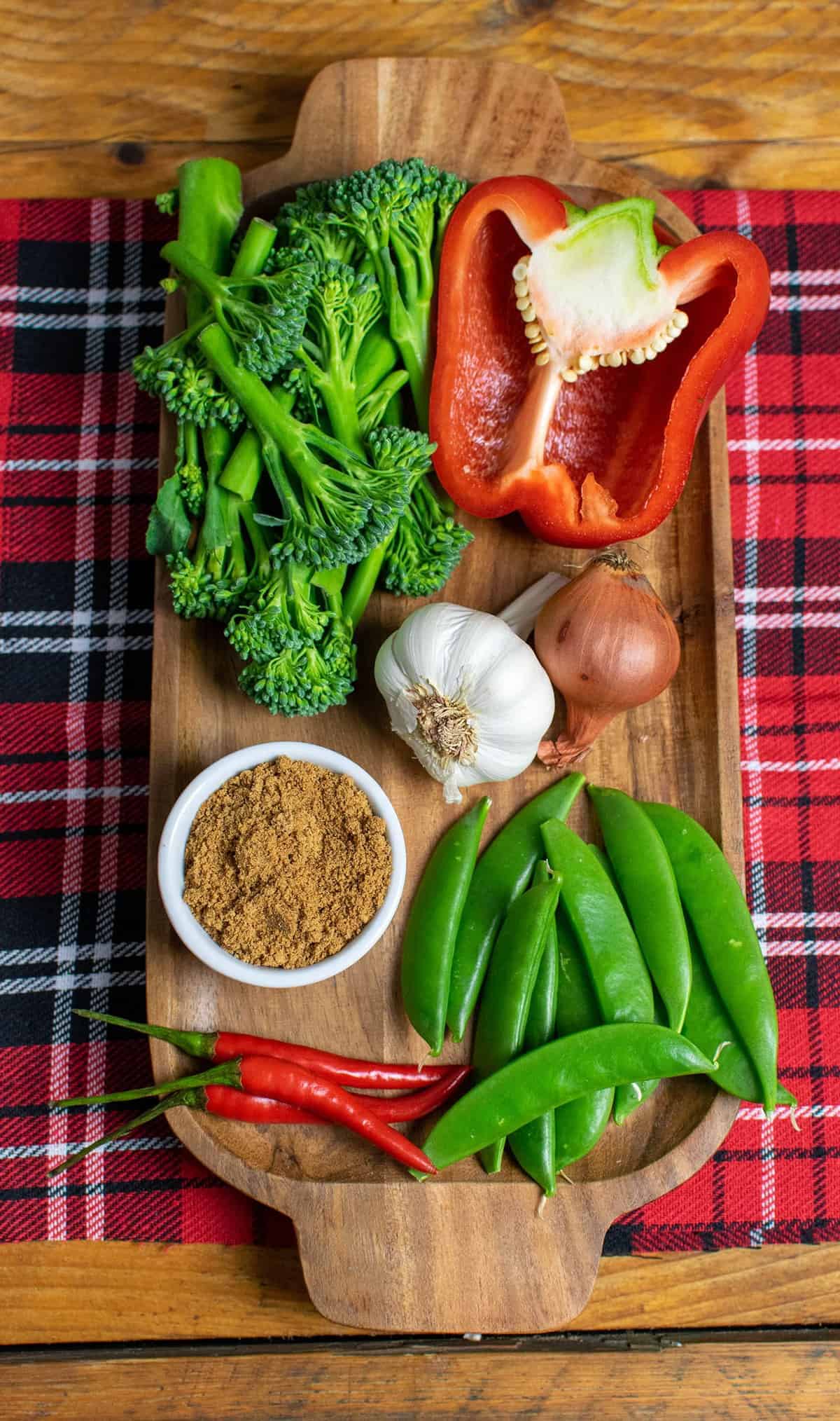 Vegetables on a brown wooden tray ready for stir frying