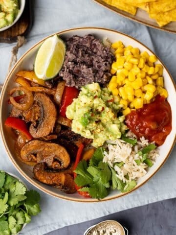 Mexican Buddha bowl with avocado, rice, mushrooms, peppers and sweetcorn.