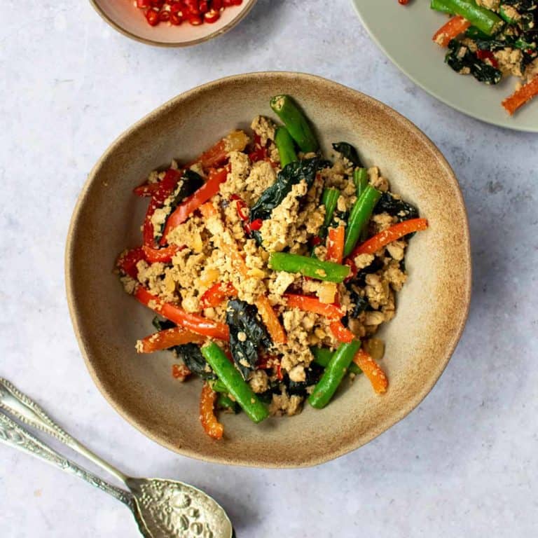 Square image of Thai Basil Tofu in a bowl with spoons in front of it