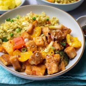 Sweet and sour tofu served with fried rice in a bowl.