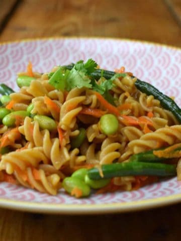 Asian pasta salad on a pink plate