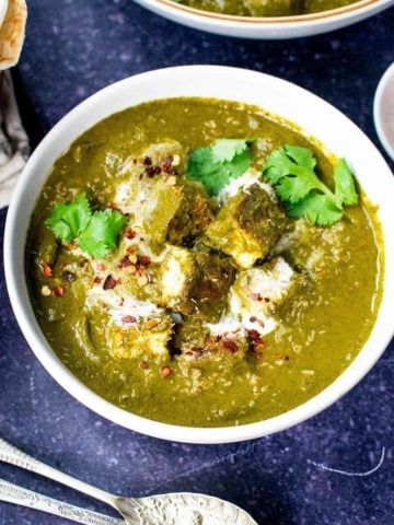 Vegan palak paneer in a bowl on a blue background