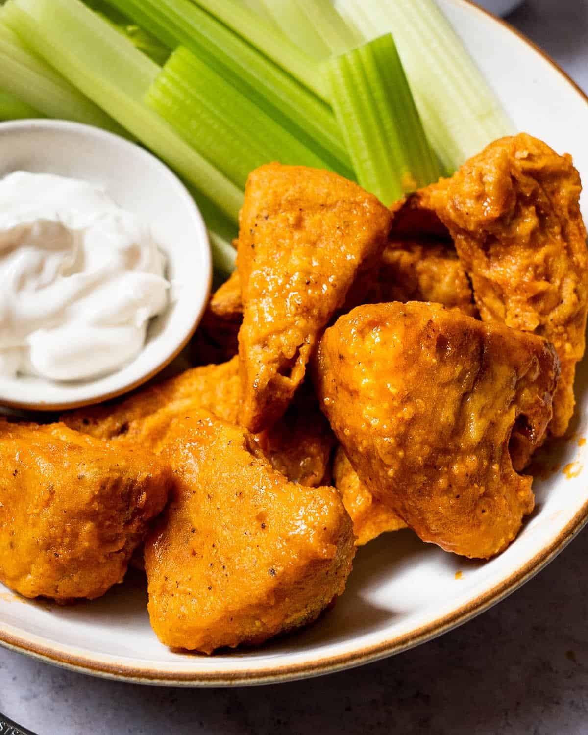 Fried jackfruit in a bowil with celery and a dipping sauce.