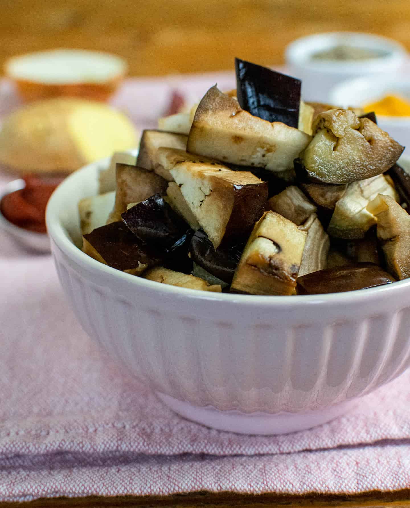 A pink bowl filled with cooked chopped aubergine