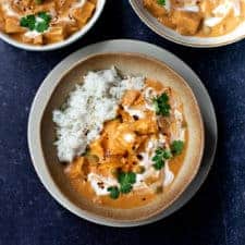 square image of vegan butter chicken in a bowl with two other bowls above it