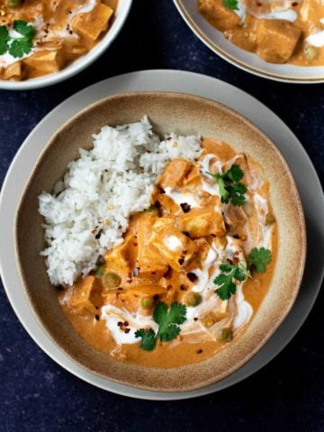 square image of vegan butter chicken in a bowl with two other bowls above it