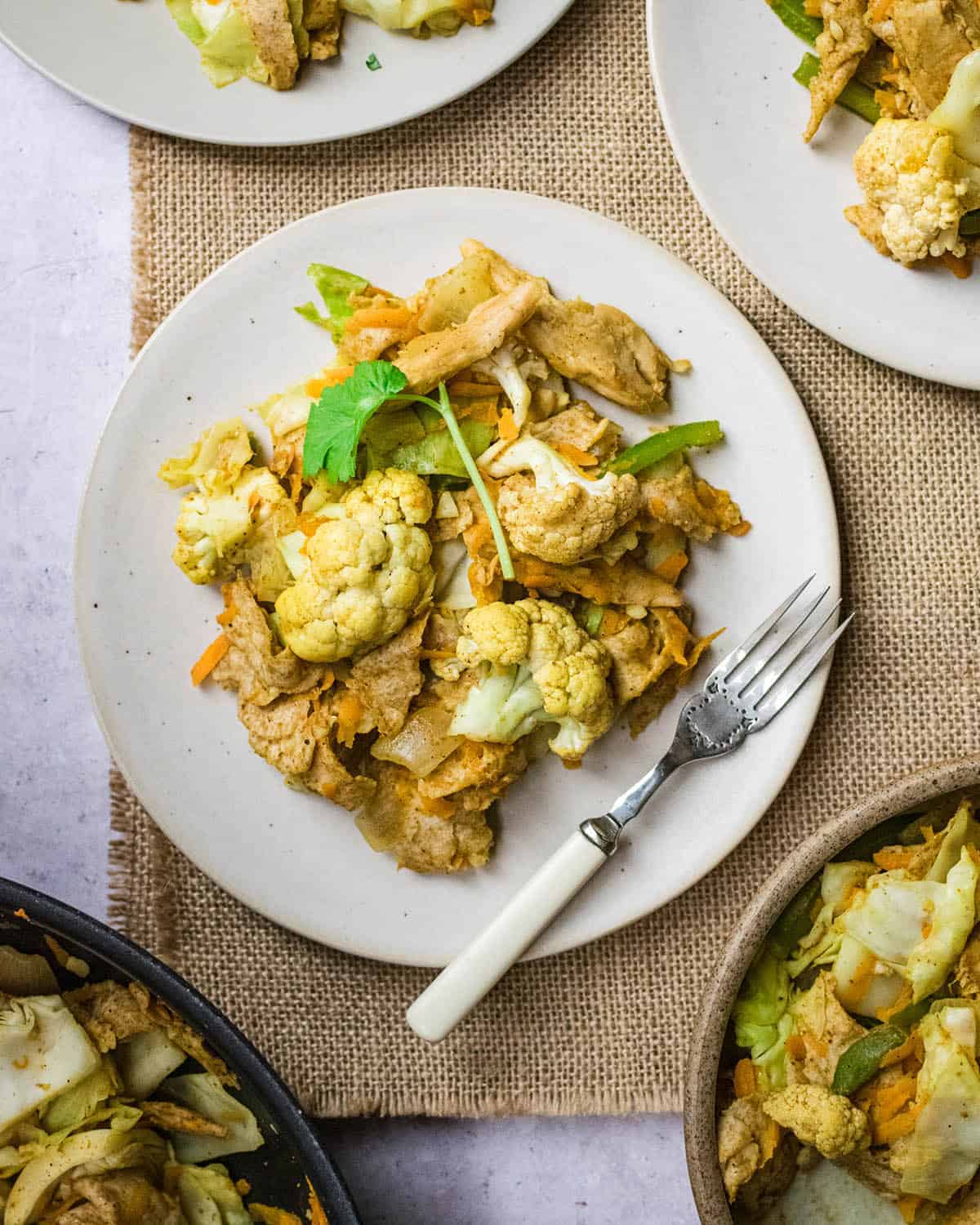 Kothu Parotta on a plate with 4 other plates around it