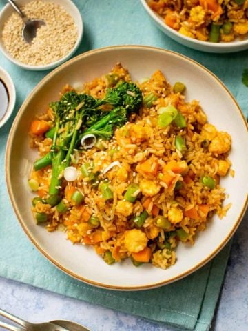 Vegan kimchi fried rice in a bowl with pinch bowls surrounding it