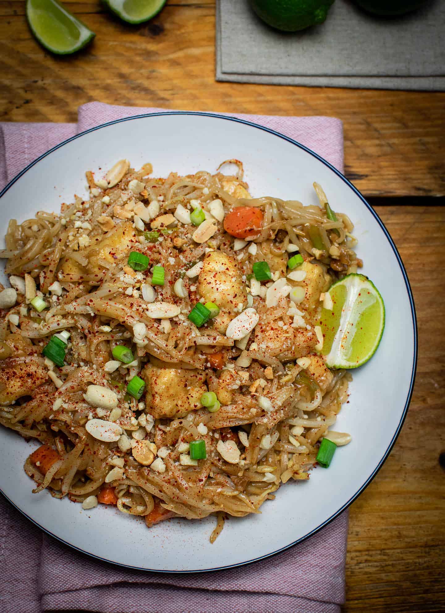 Easy vegan Pad Thai served with a wedge of lime and sprinkled with chopped peanuts