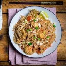 Easy vegan pad Thai on a plate with chopsticks above, ready to eat