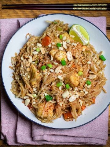 Easy vegan pad Thai on a plate with chopsticks above, ready to eat