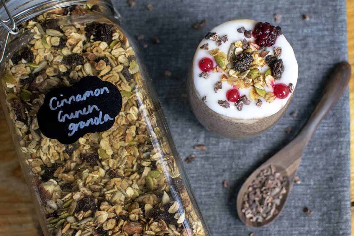 Cinnamon granola in a clip top jar labelled 'Cinnamon Crunch Granola' alongside a jar that is holding chia