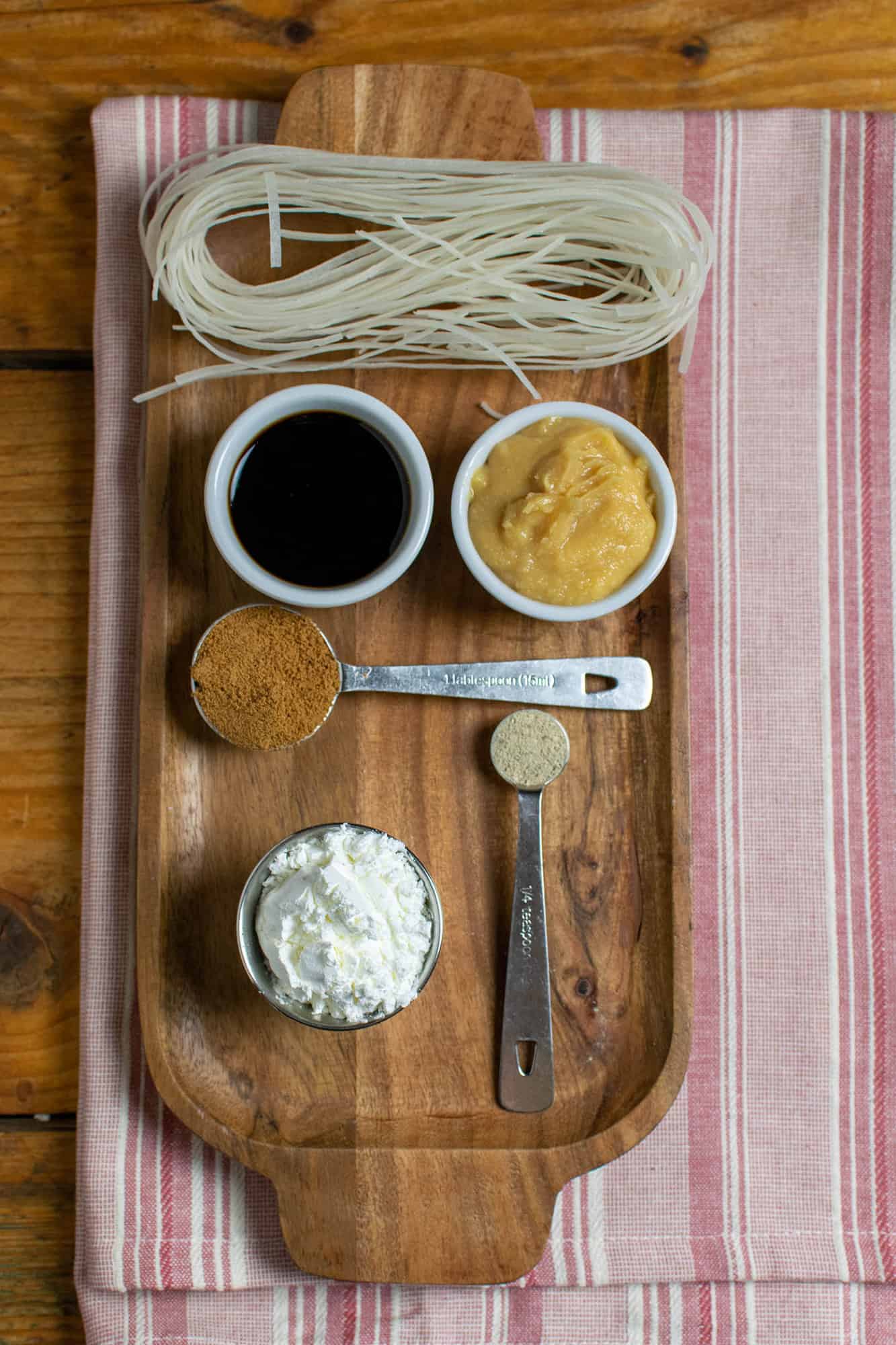 Ingredients laid out on a wooden tray on a pink stripy towel. Miso paste, soy sauce, cornflour, sugar and white pepper can be seen.