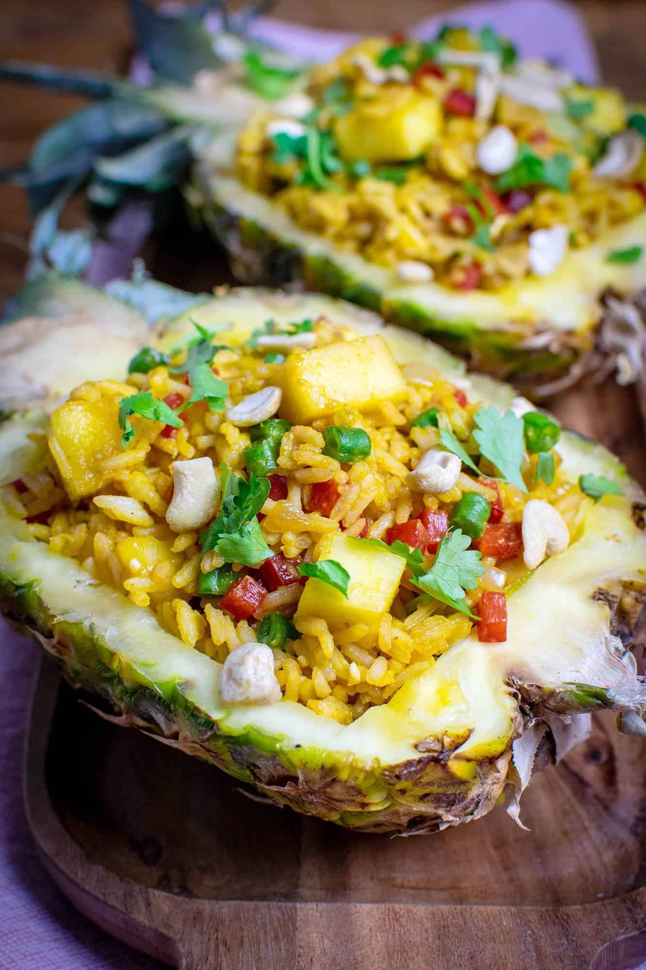 Two hollowed out pineapples filled with Vegan Pineapple Fried rice