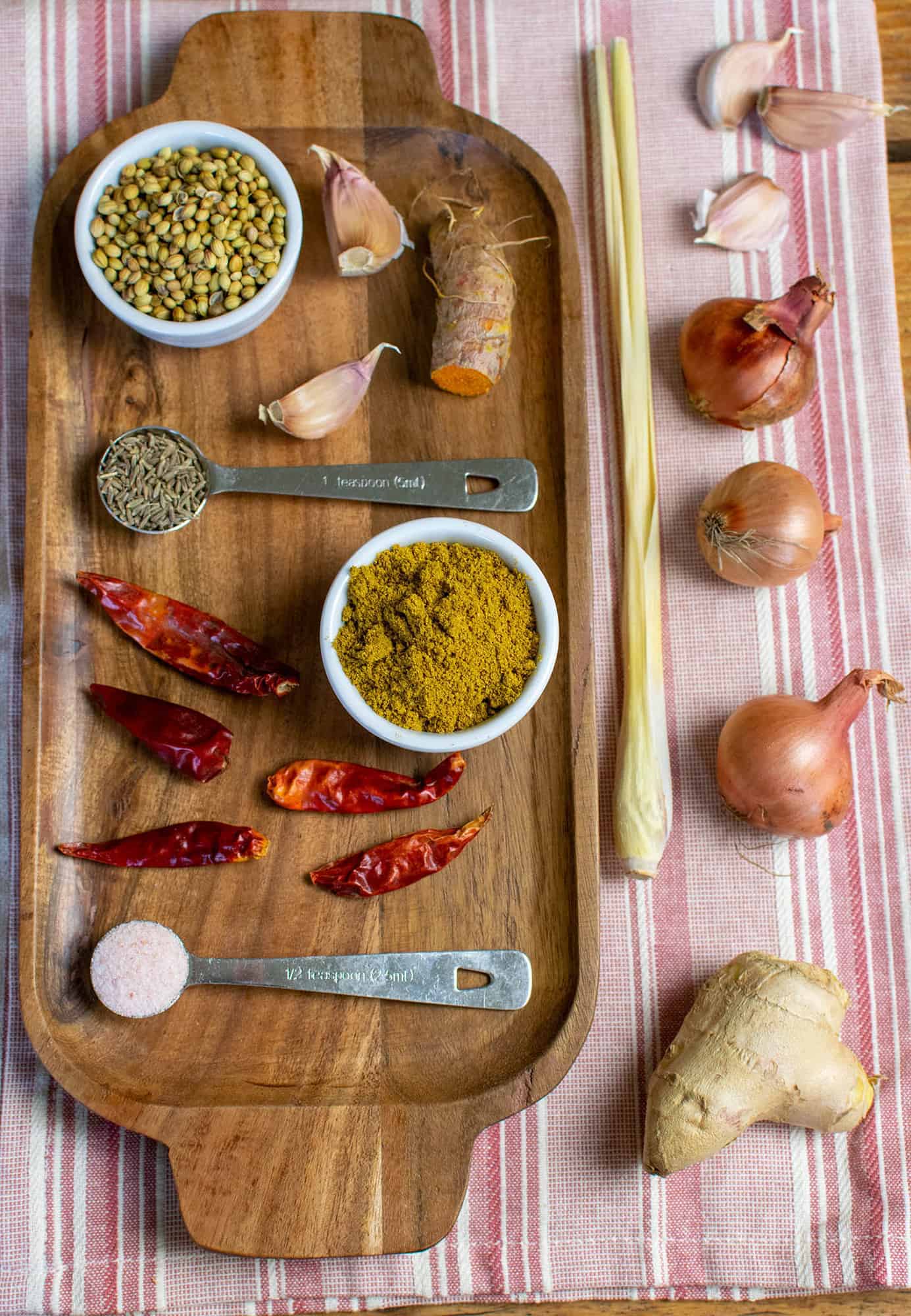 Ingredients for vegan Thai yellow curry paste laid out on a wooden tray