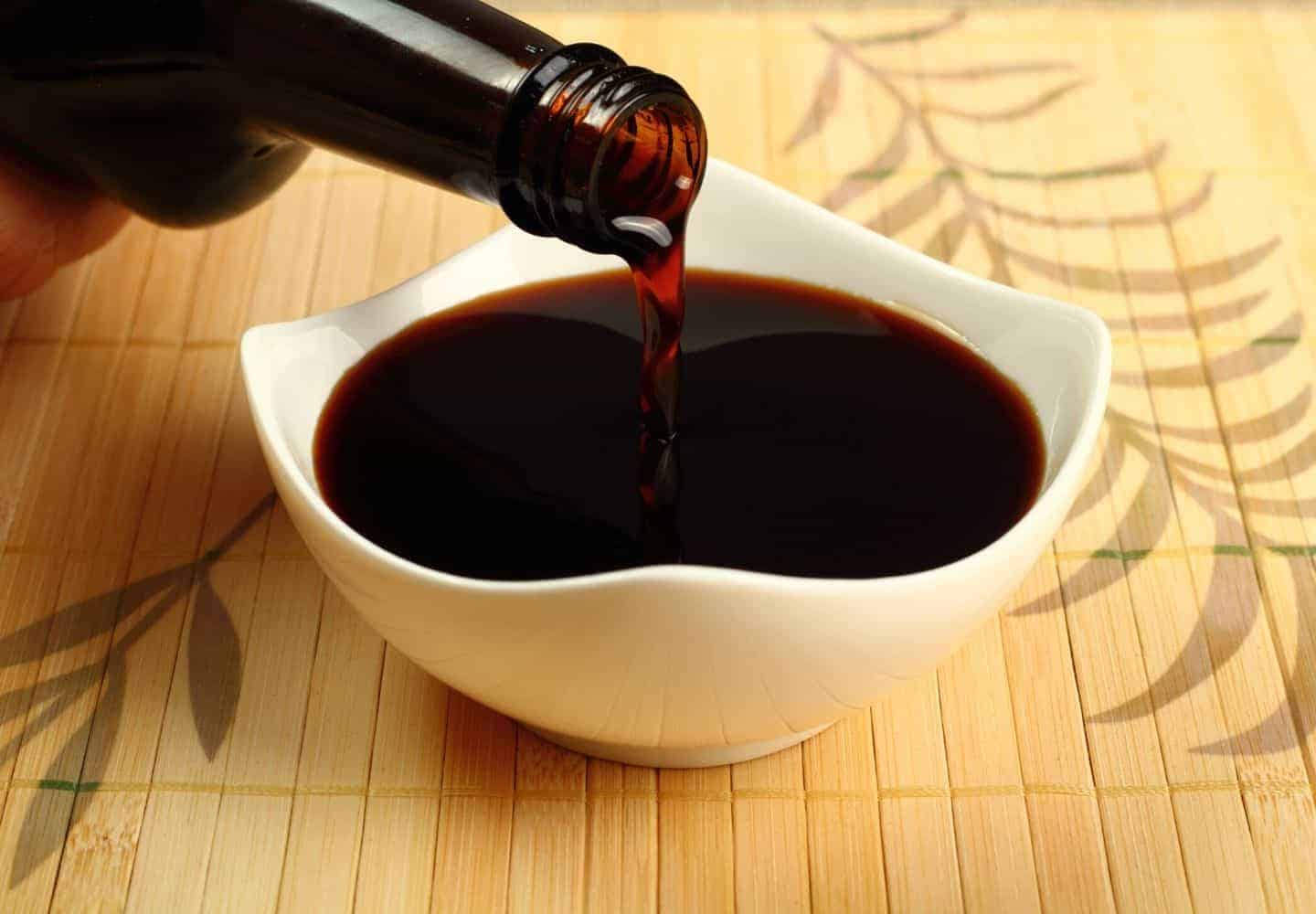 Soy sauce being poured out into a small dish