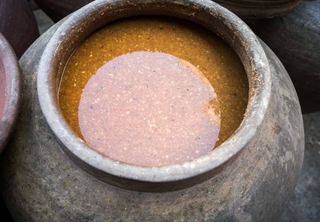 A big ceramic jar full of a brown paste