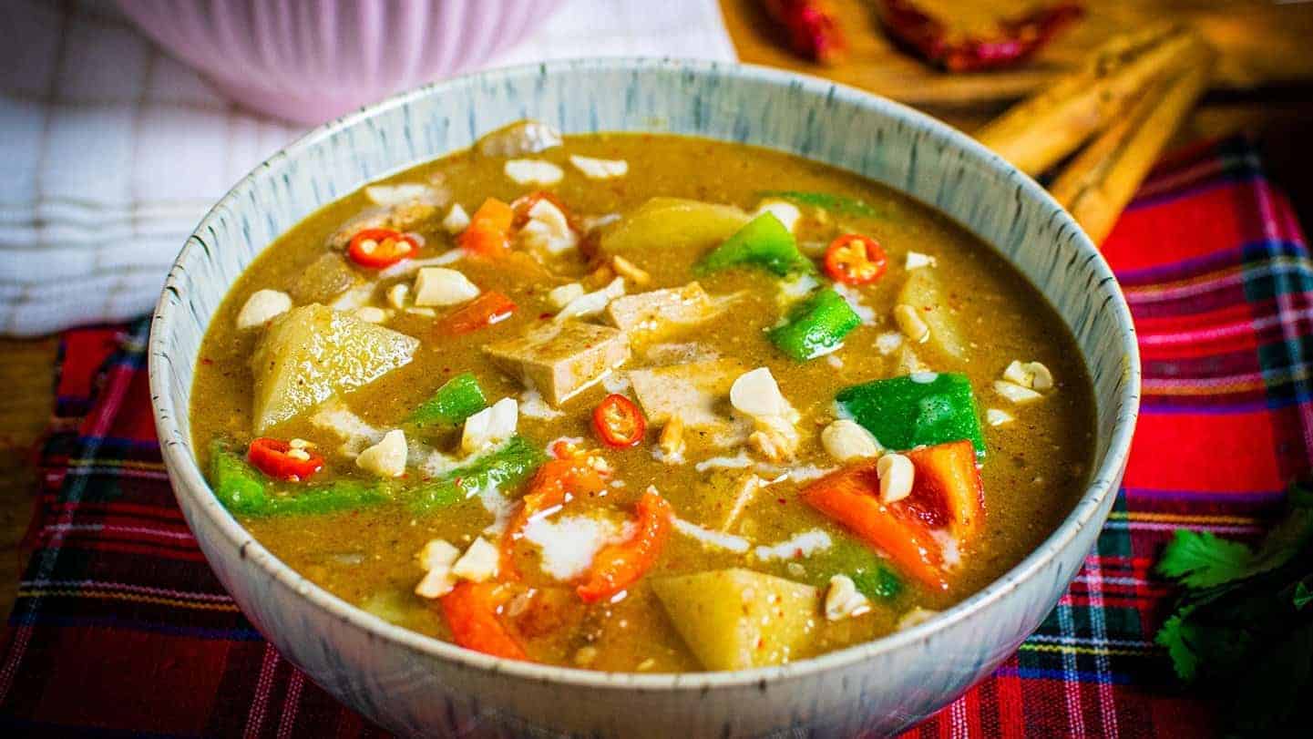 Landscape image showing vegetable Massaman curry in a blue speckled bowl