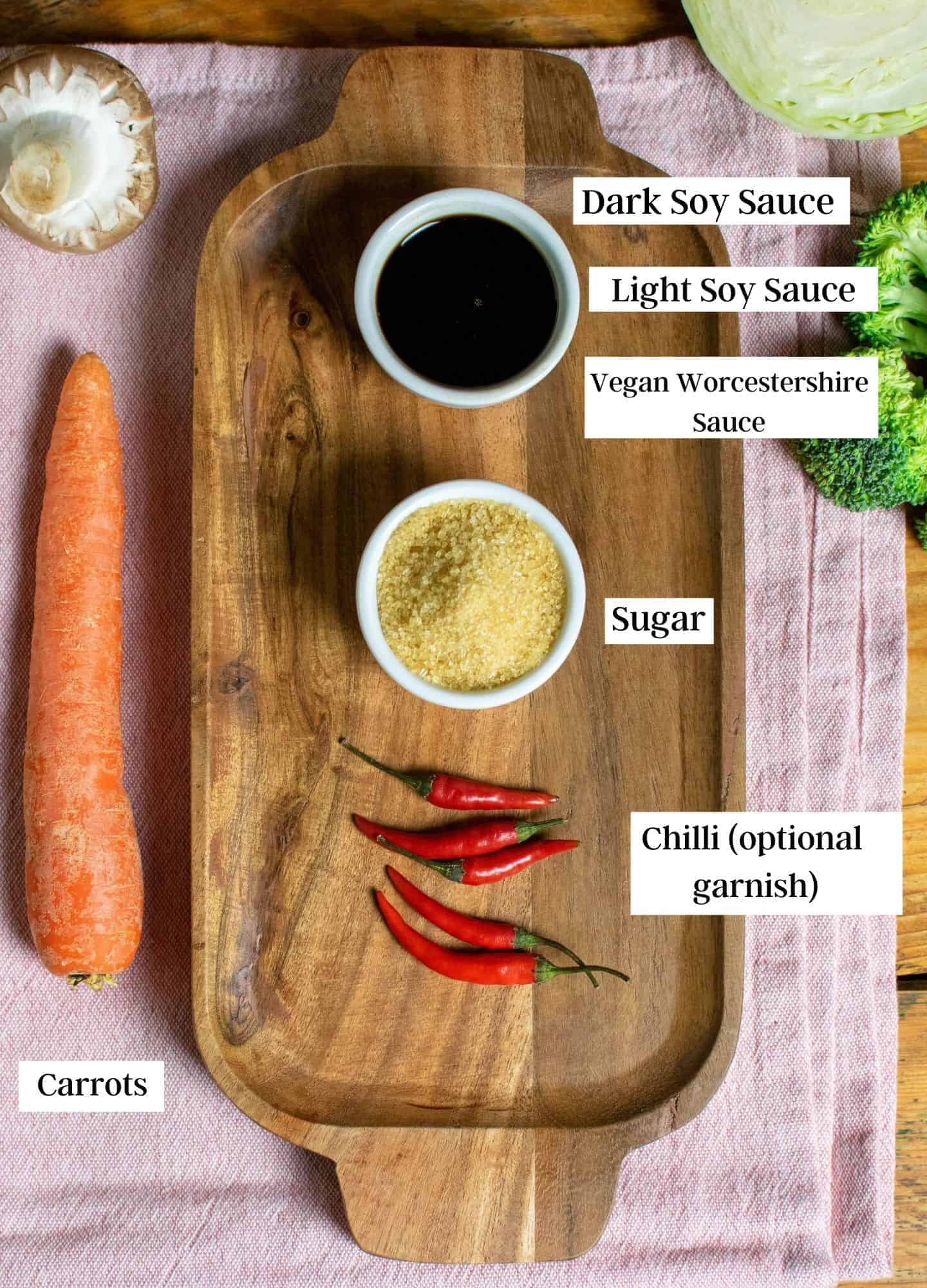 Ingredients laid out on a chopping board, focusing on the soy sauces, sugar and chillies for garnish