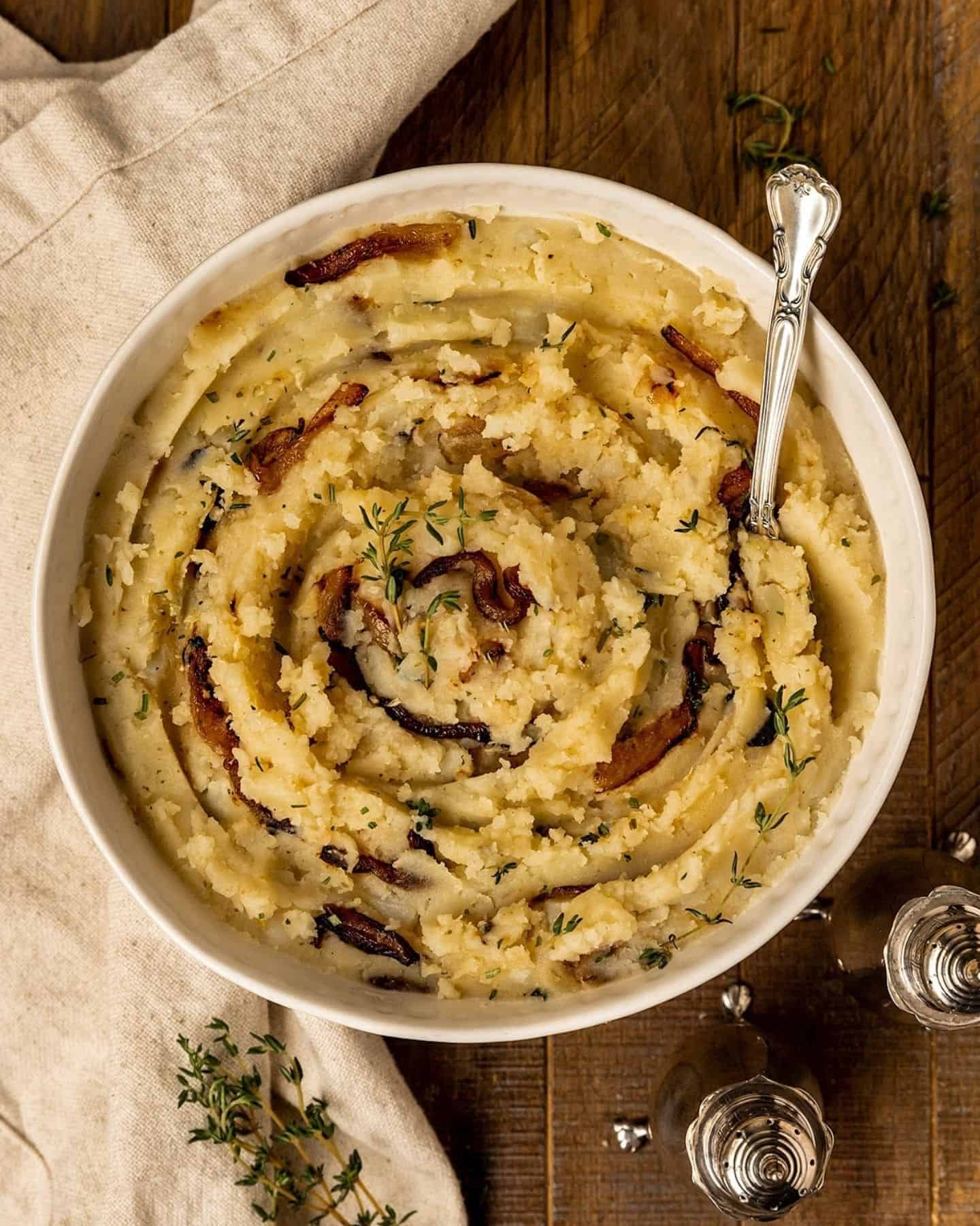 Caramelised mash potato in a white bowl with onion in it