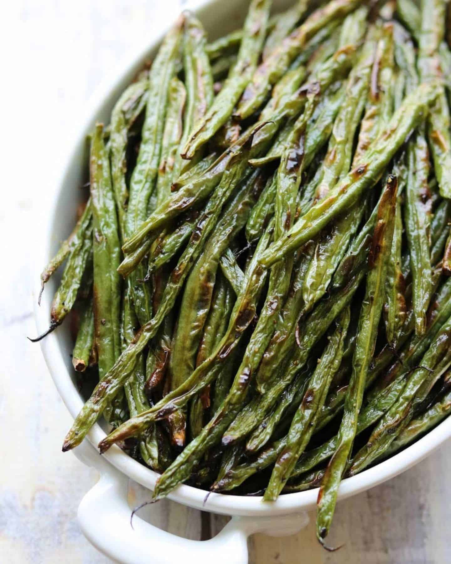 Blistered green beans in a white bowl