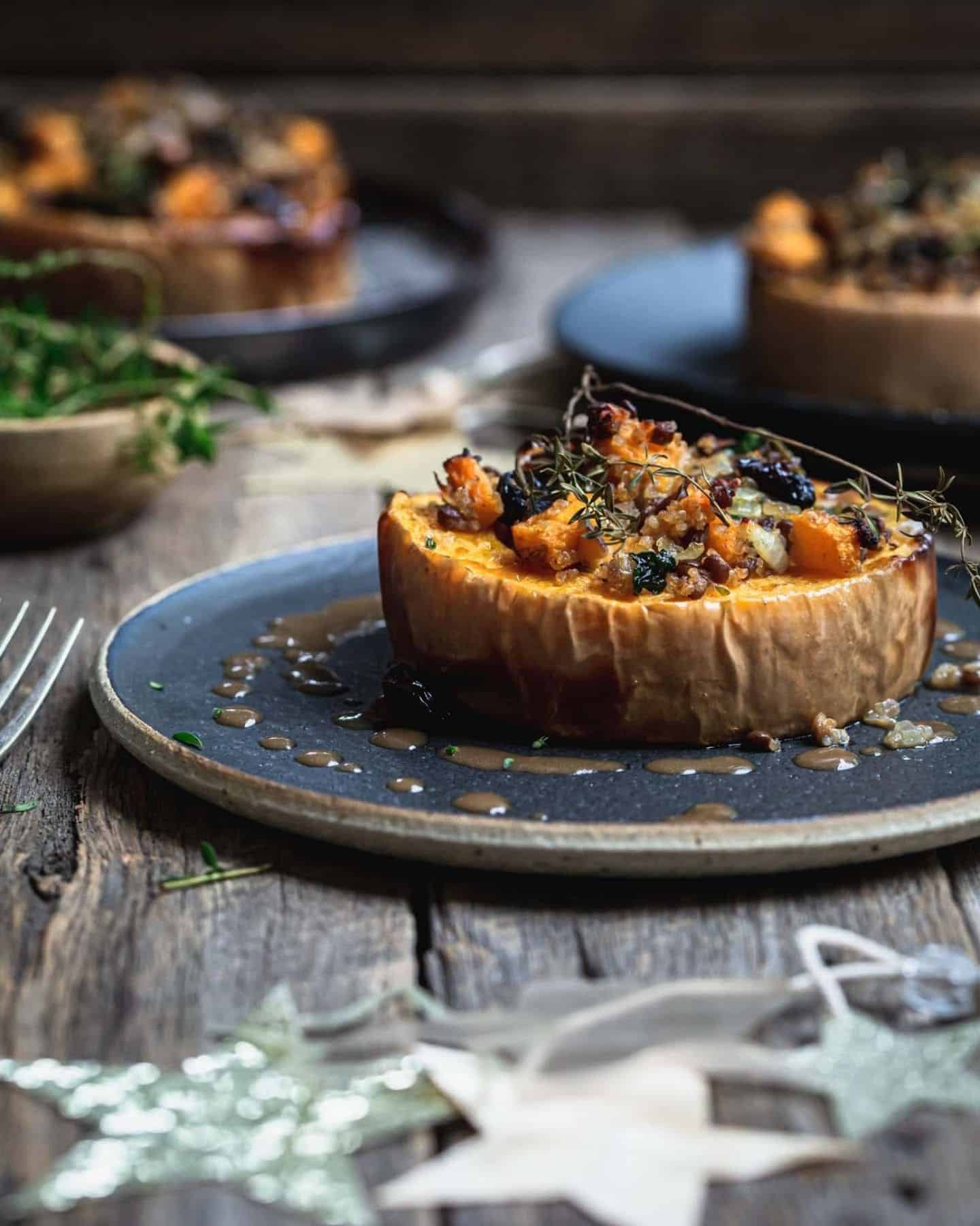 A slice of roasted squash with stuffing on top of it on a blue plate with stars in the foreground