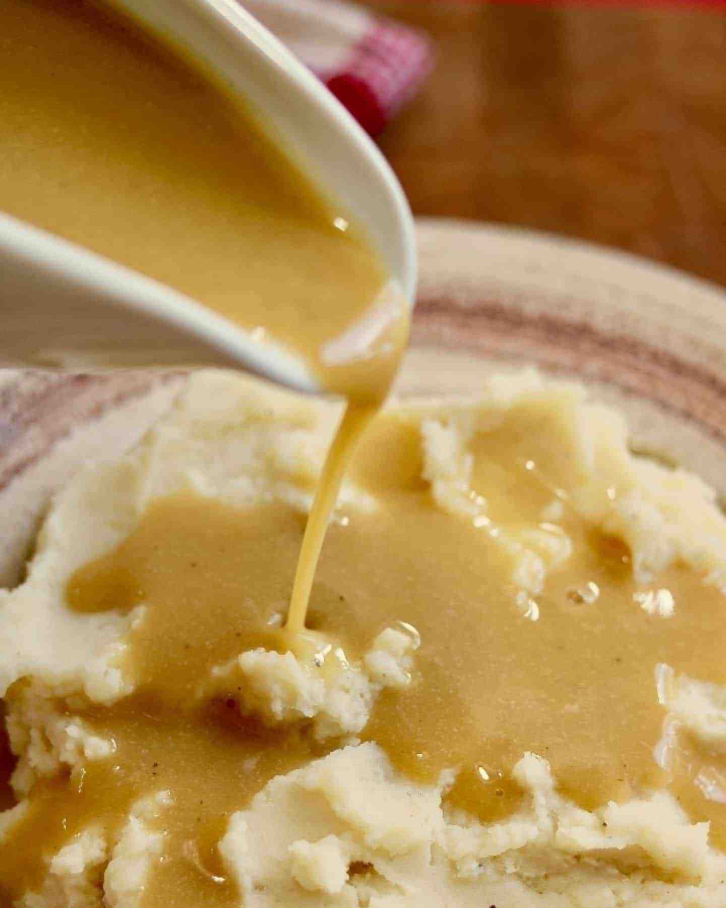 Gravy being poured on to a plate of mashed potato