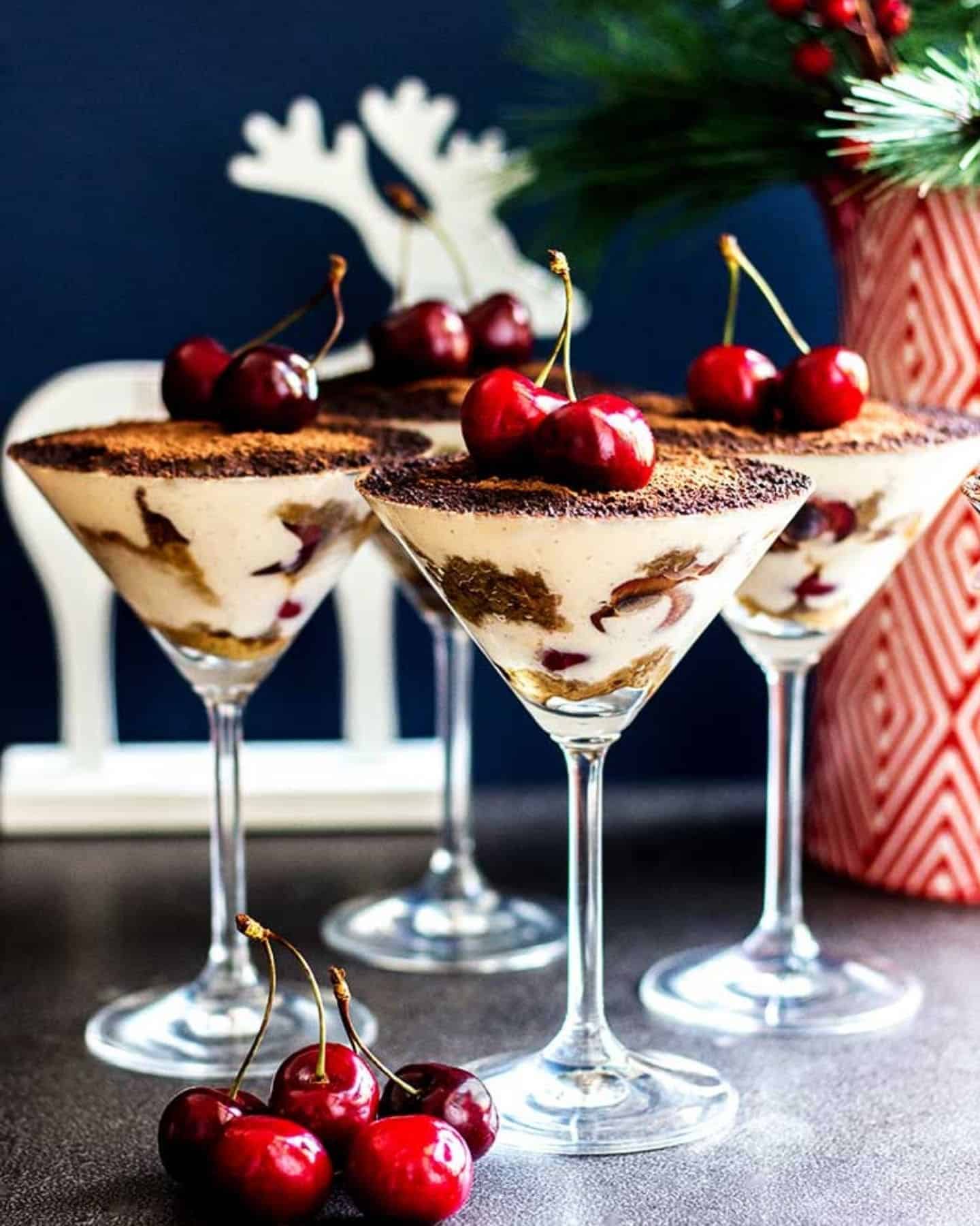 Vegan tiramisu in martini glasses with a reindeer ornament in the background