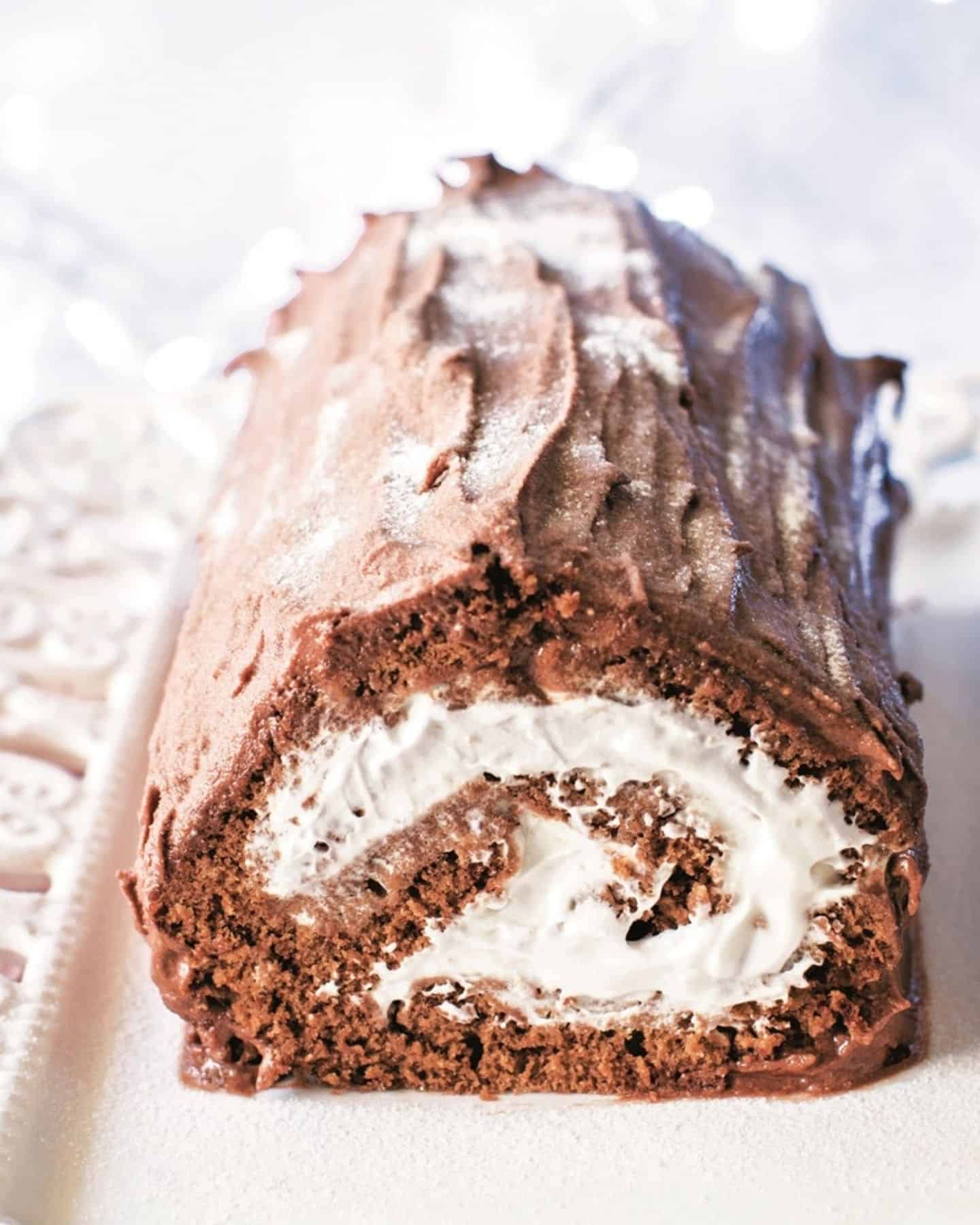 Vegan yule log showing the cream swirl, on a serving plate