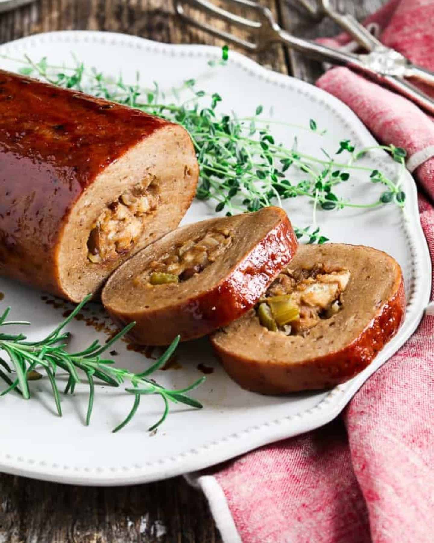 Vegan Holiday Roast served on a white plate with herbs, as part of a vegan Christmas dinner