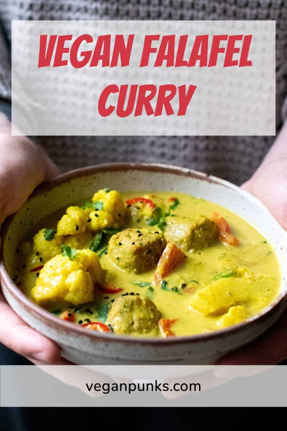 A man's hands holding a bowl of falafel curry with a Pinterest title above the image and our website name below