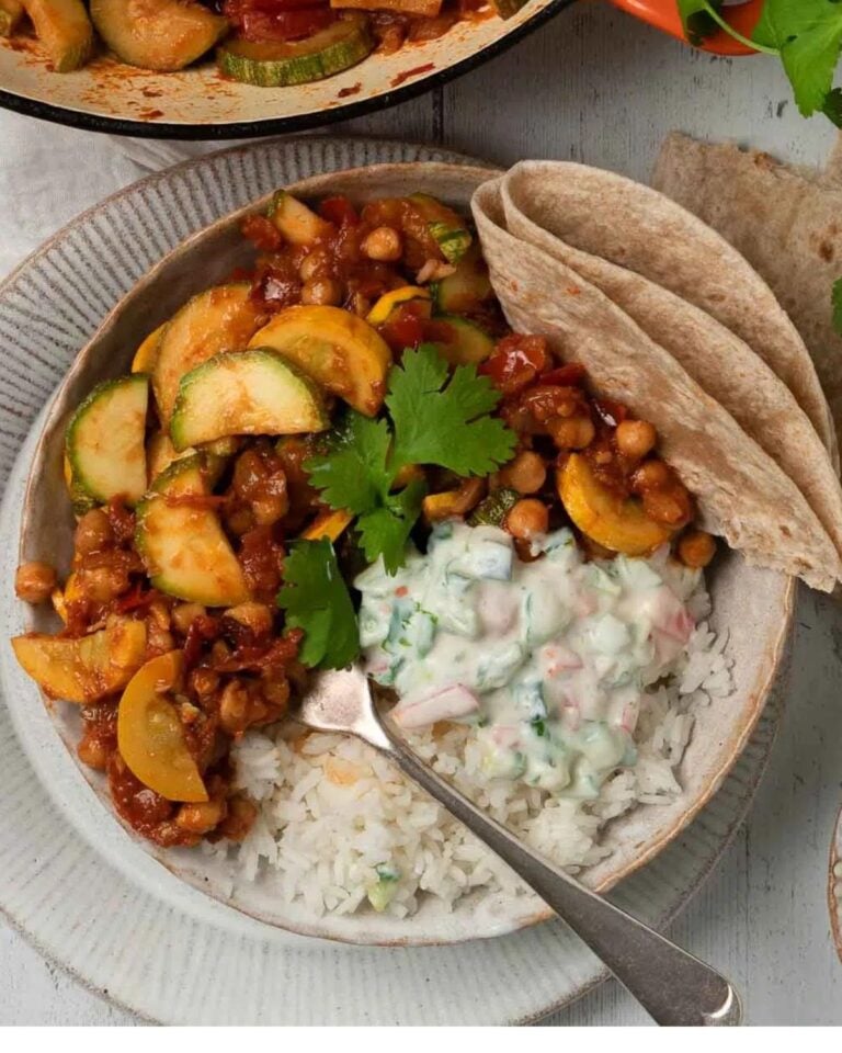 Courgette and chickpea curry with raita, chapati, rice and fresh corainder.