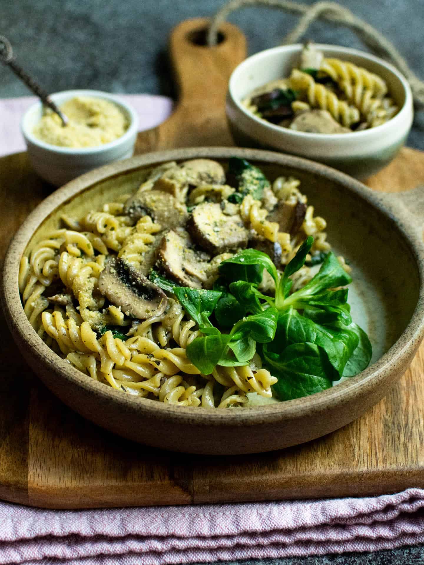 A bowl of creamy pasta topped with some leaves.