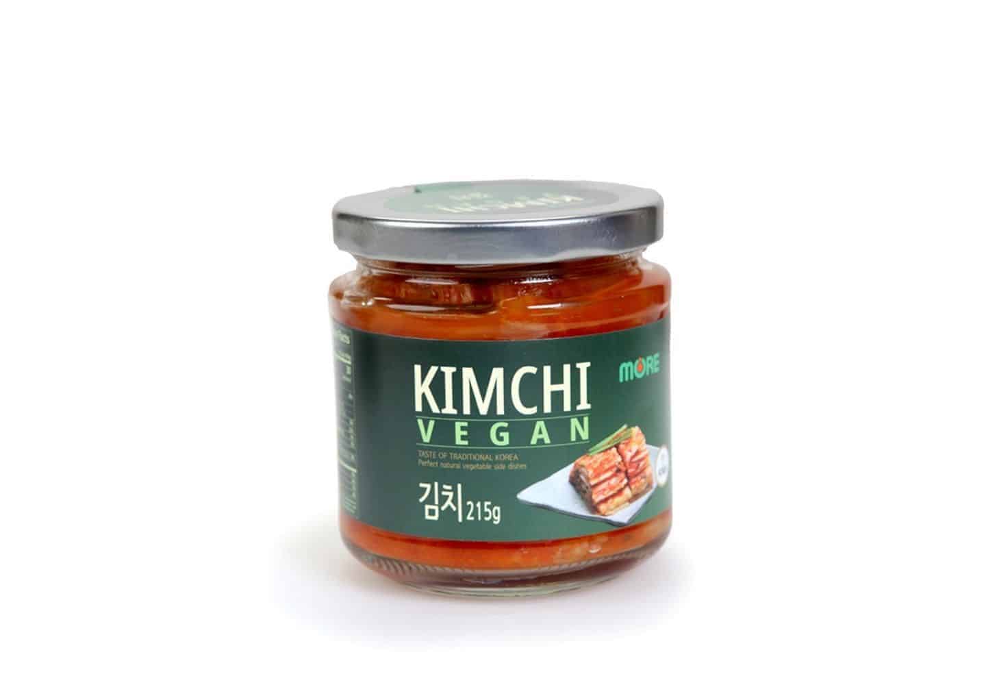 A jar of kimchi on a white background. The label says 'vegan' and the contents of the jar is red