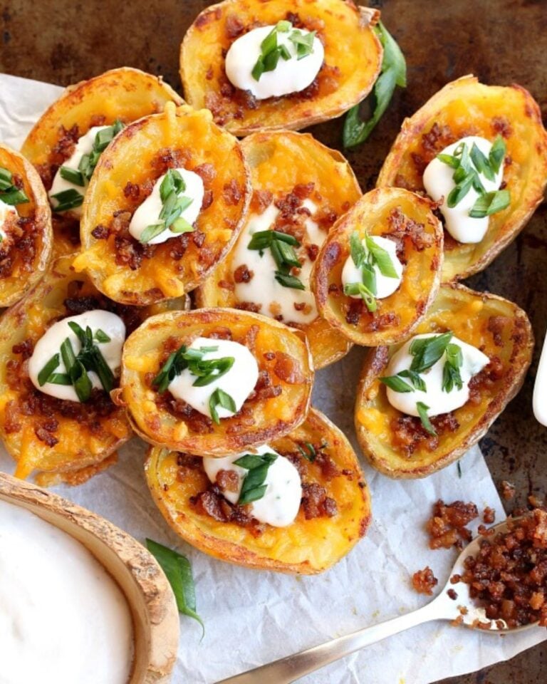 Potato skins filled with vegan cheese and topped with sour cream and plant bacon bits.