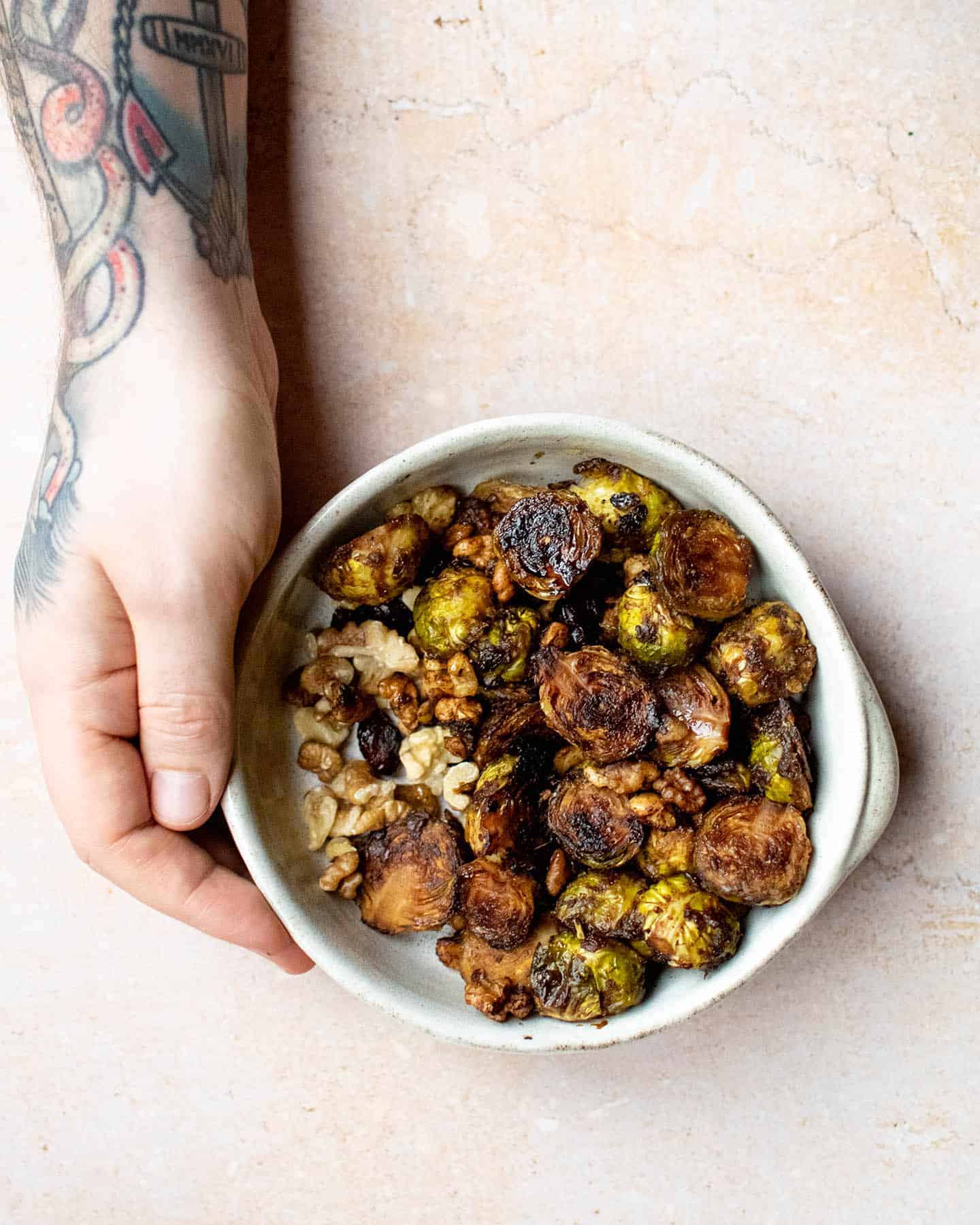 A white bowl containing browned, roasted sprouts.