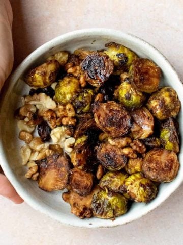 A bowl of roasted sprouts and walnuts.