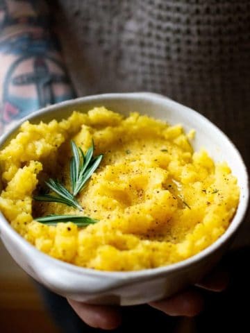 A bowl of swede mash being held