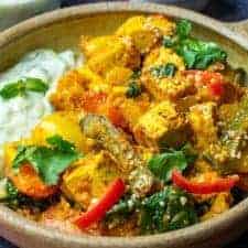 Vegetable bhuna close up with vegan raita on the side of the dish next to the curry