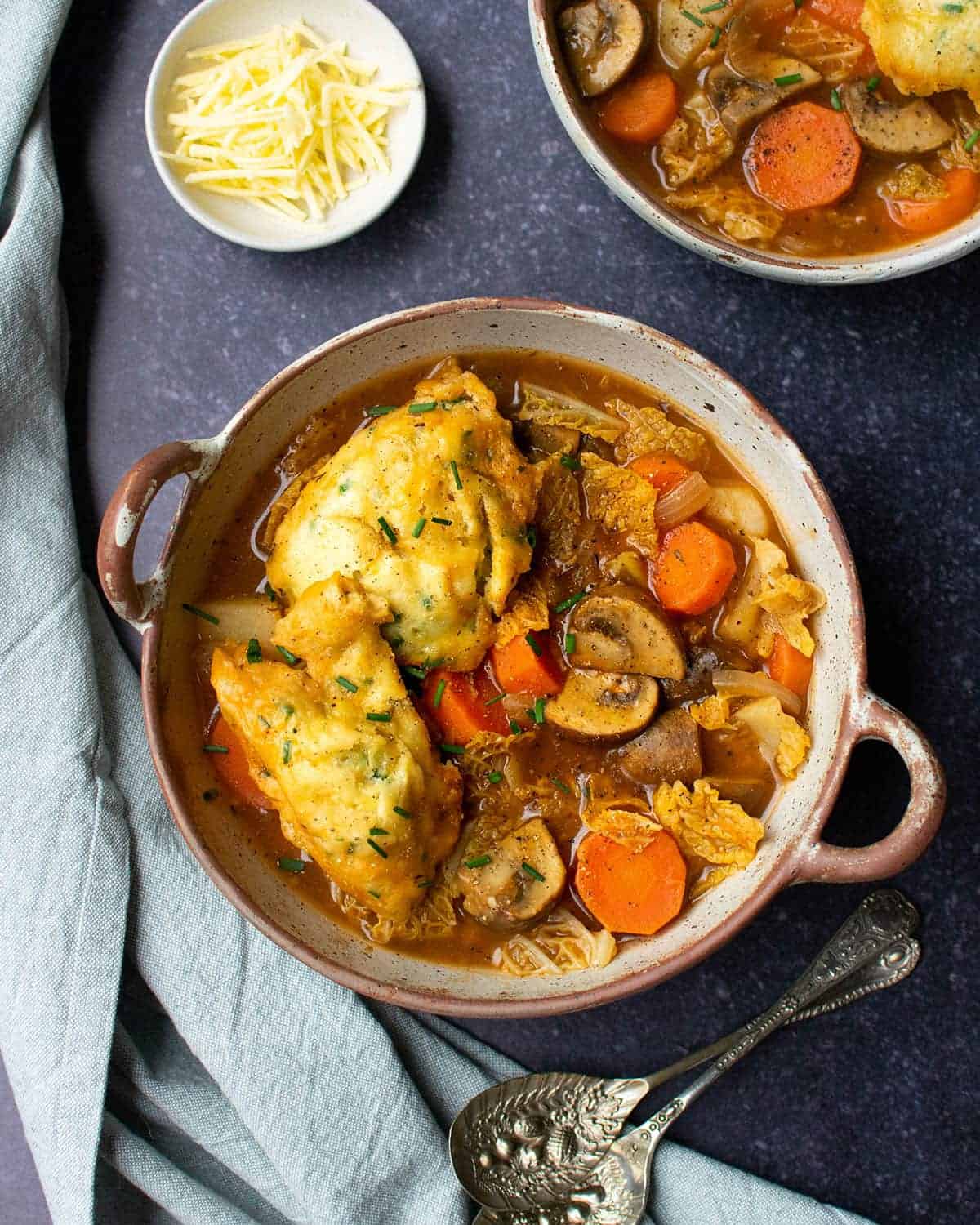 Top down view of vegan stew and dumplings with carrots, potatoes and cabbage.