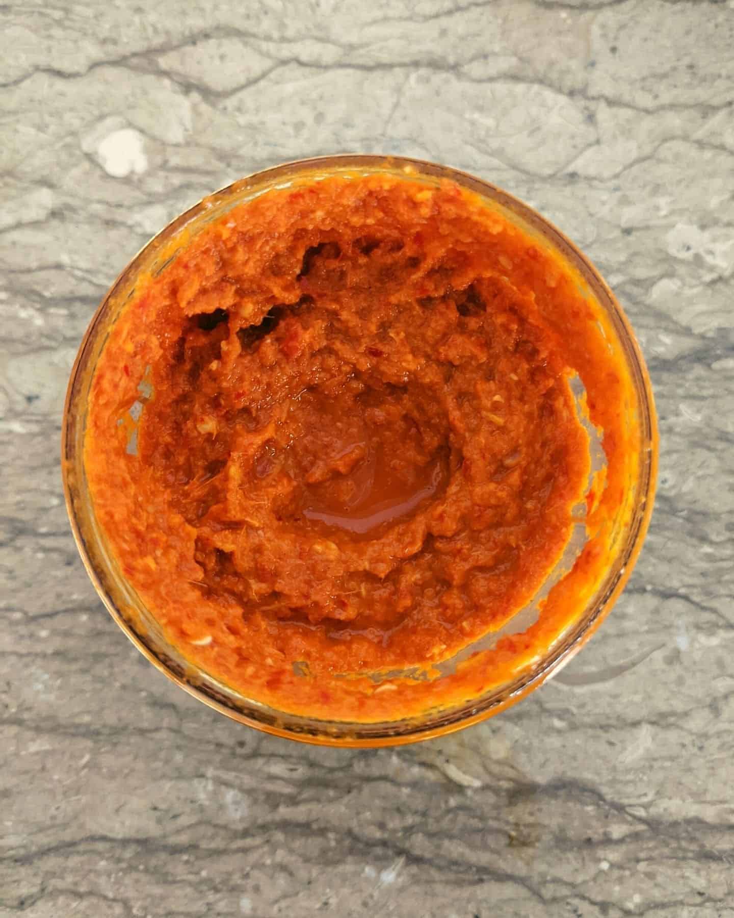 Top down view of red rendang curry paste in a cup