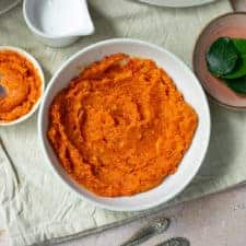 Close up of sambal goreng in a white bowl with small pots surrounding it, in a square image