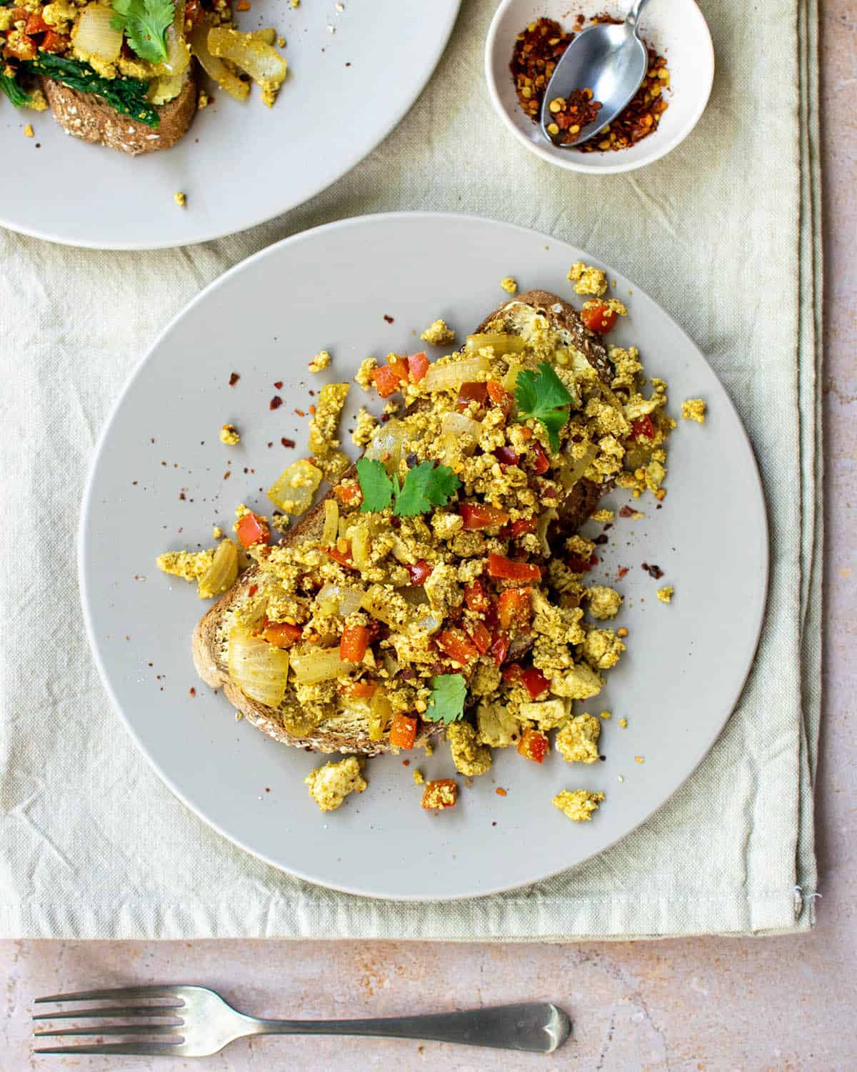 Curried tofu scramble on a piece of toast on a plate